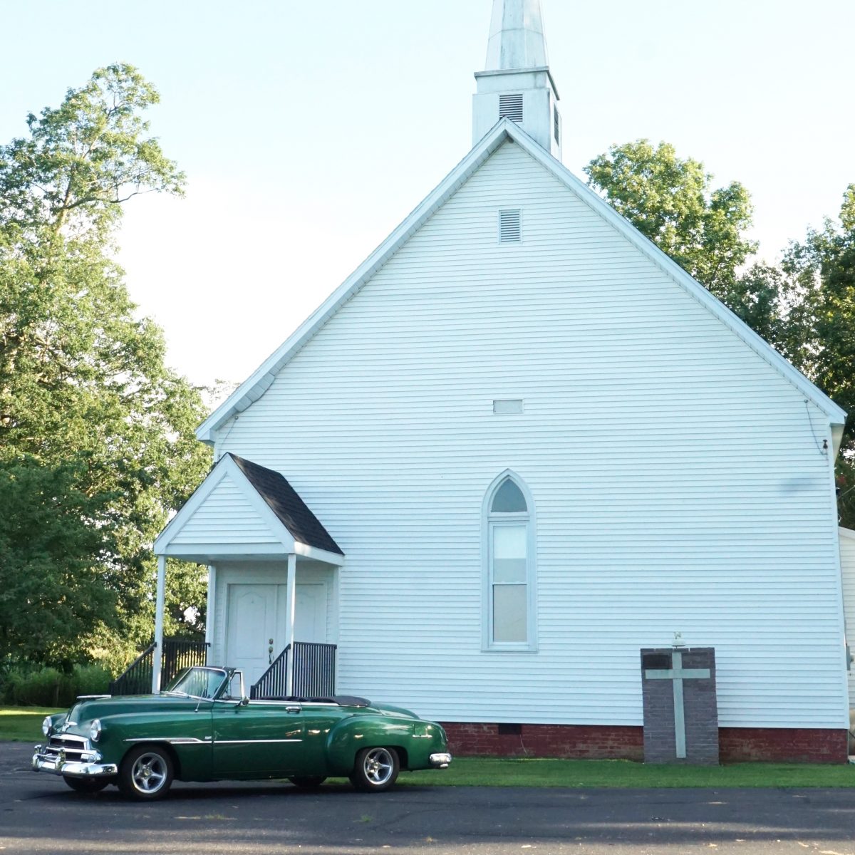 photo of classic car in front of white church